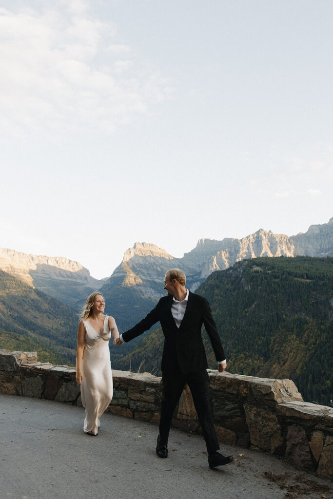 Couple sits on ledge in Glacier National Park