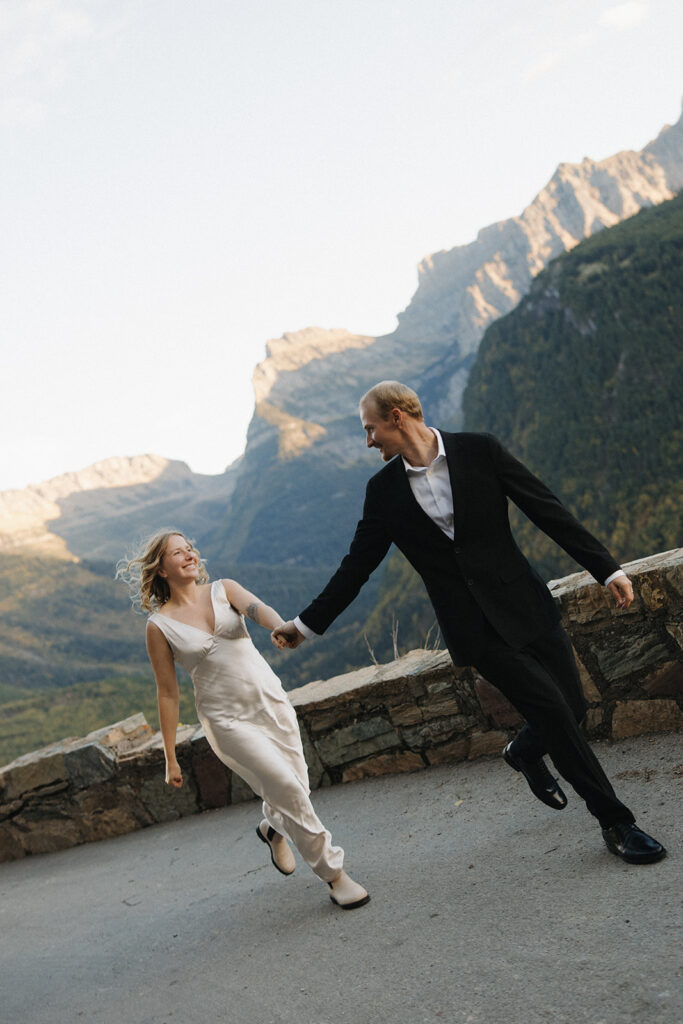 Couple sits on ledge in Glacier National Park