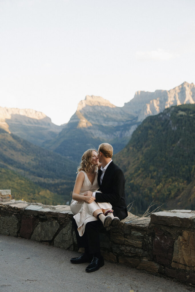 Couple sits on ledge in Glacier National Park