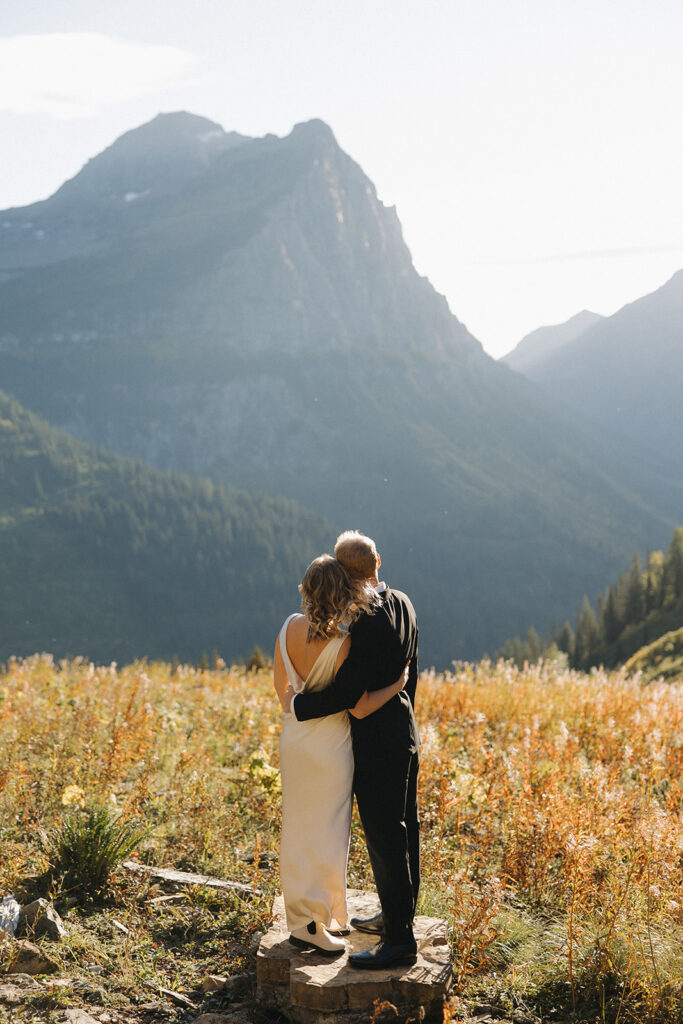 Couple stands on rock in Glacier National Park