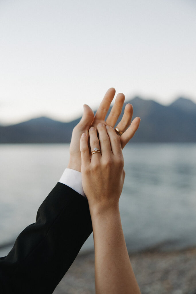 Couples hands at sunset over a lake in Glacier National Park