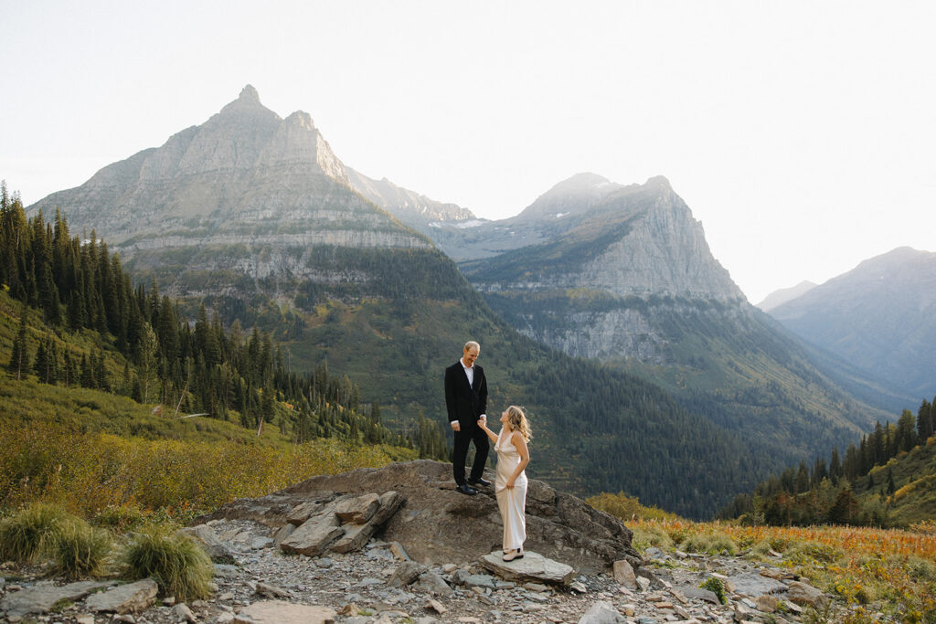 Couple stands on rock in Glacier National Park