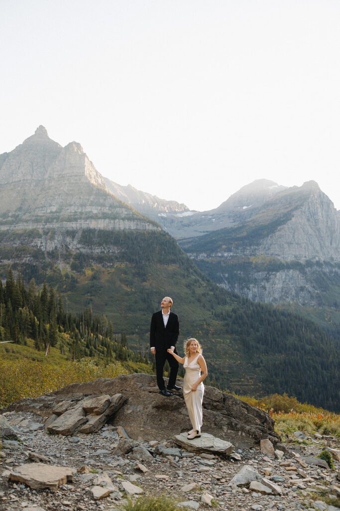 Couple stands on rock in Glacier National Park