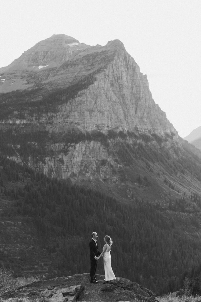 Couple stands on rock in Glacier National Park