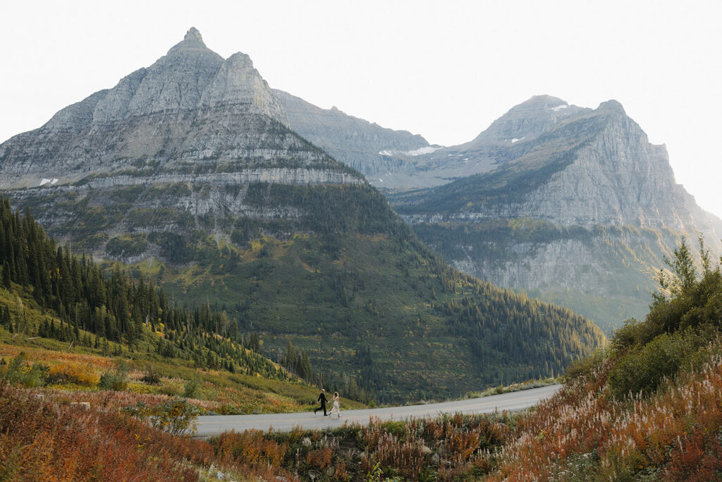 Couple runs on road in Glacier National Park