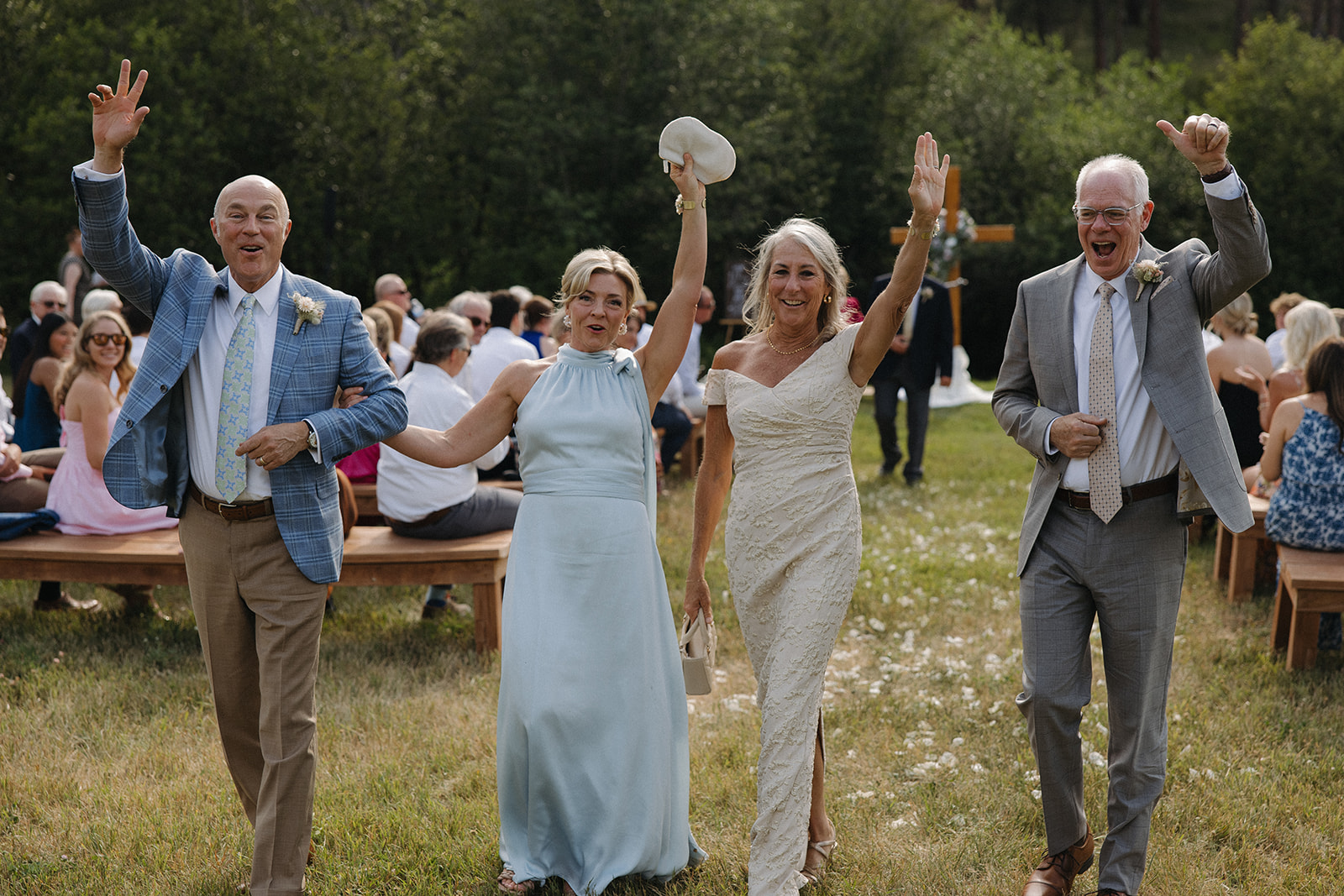 parents of both bride and groom walk up the aisle cheering at montana wedding venue