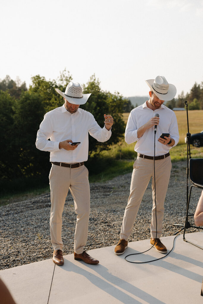 brothers wearing cowboy hats giving a toast at montana wedding venue