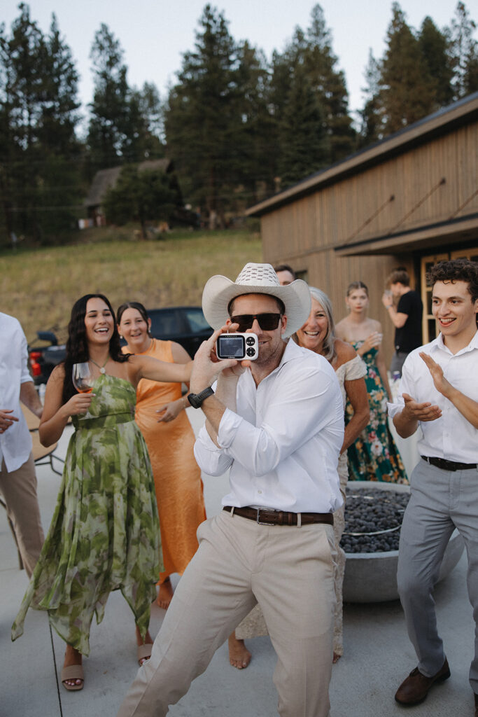 man holds baby moniter on dance floor while wearing a cowboy hat