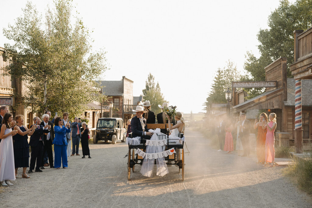 bride and groom ride horse drawn carriage at montana intimate wedding