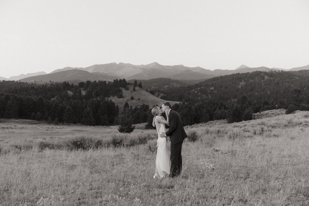 bride and groom walk through field