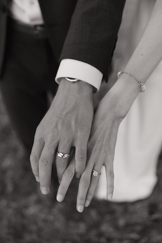 black and white of hands showing bride and grooms ring