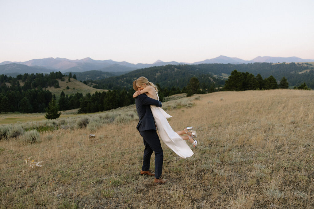 bride and groom walk through field