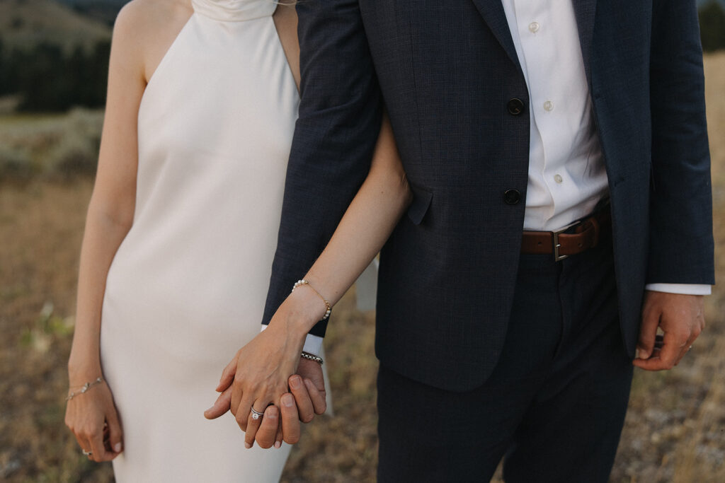 bride and groom holding hands on mountaintop