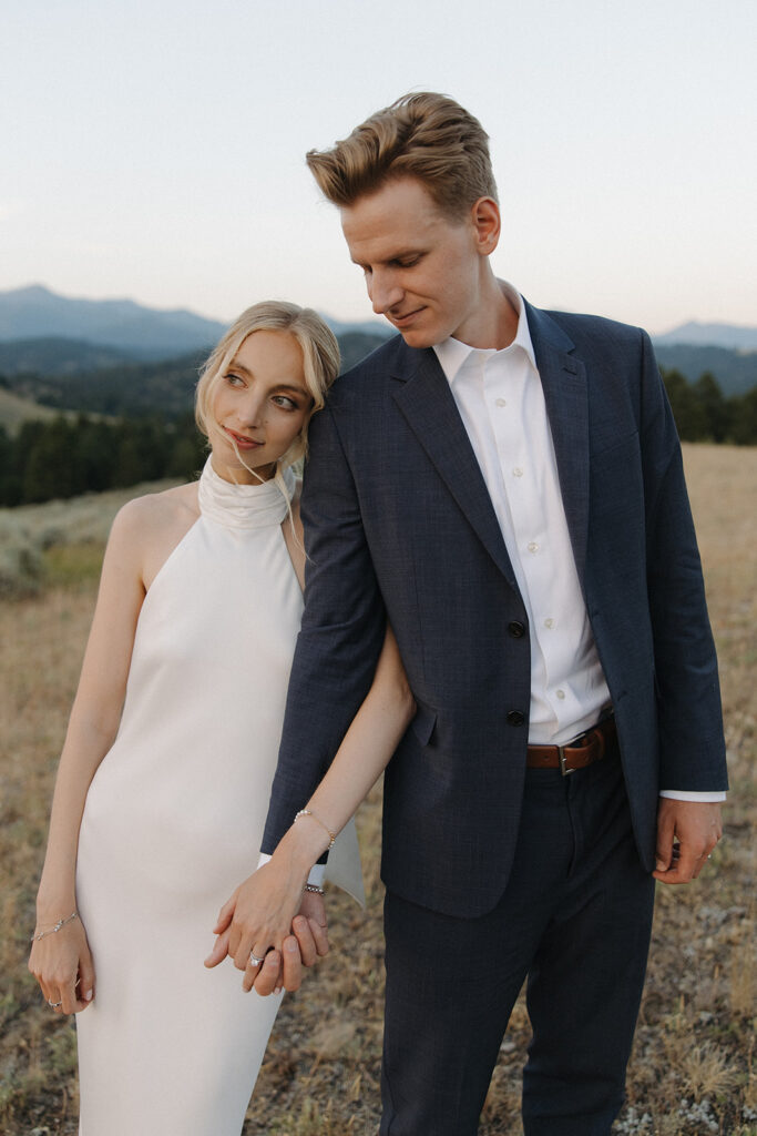 bride and groom holding hands on mountaintop