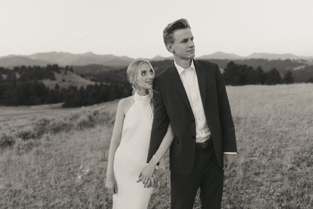 black and white bride and groom holding hands on mountaintop