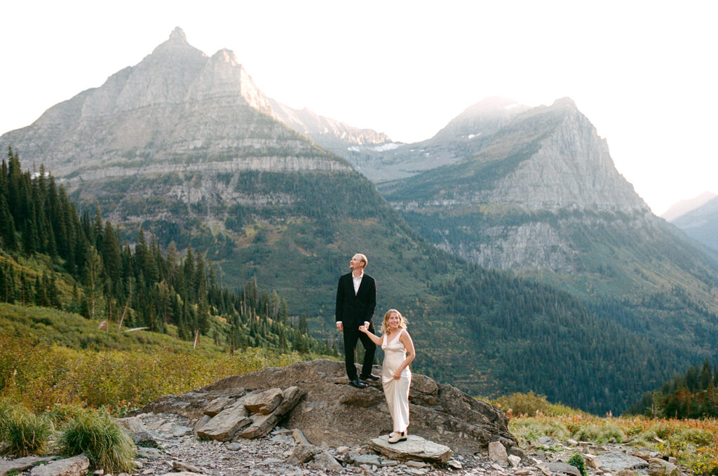 Couple stands on rock in Glacier National Park