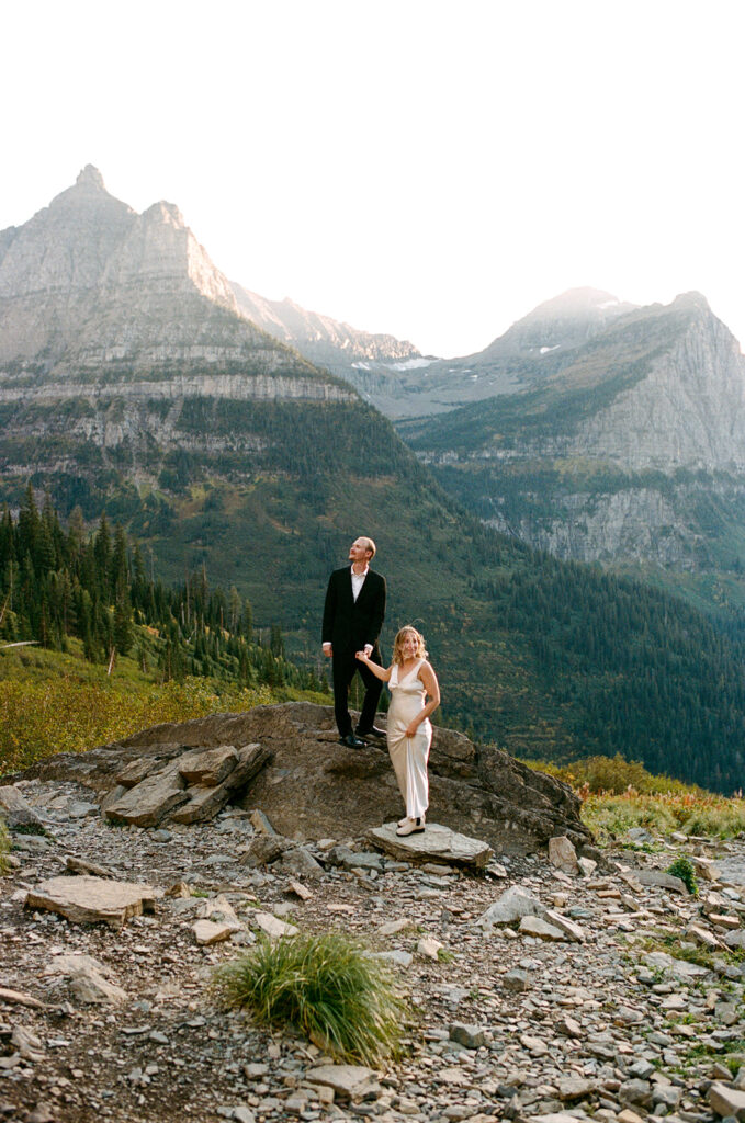 Couple stands on rock in Glacier National Park