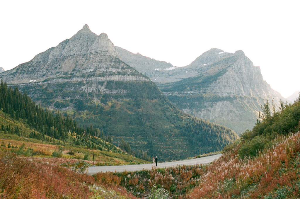 Couple runs on road in Glacier National Park