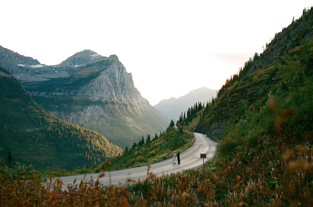 Couple runs on road in Glacier National Park