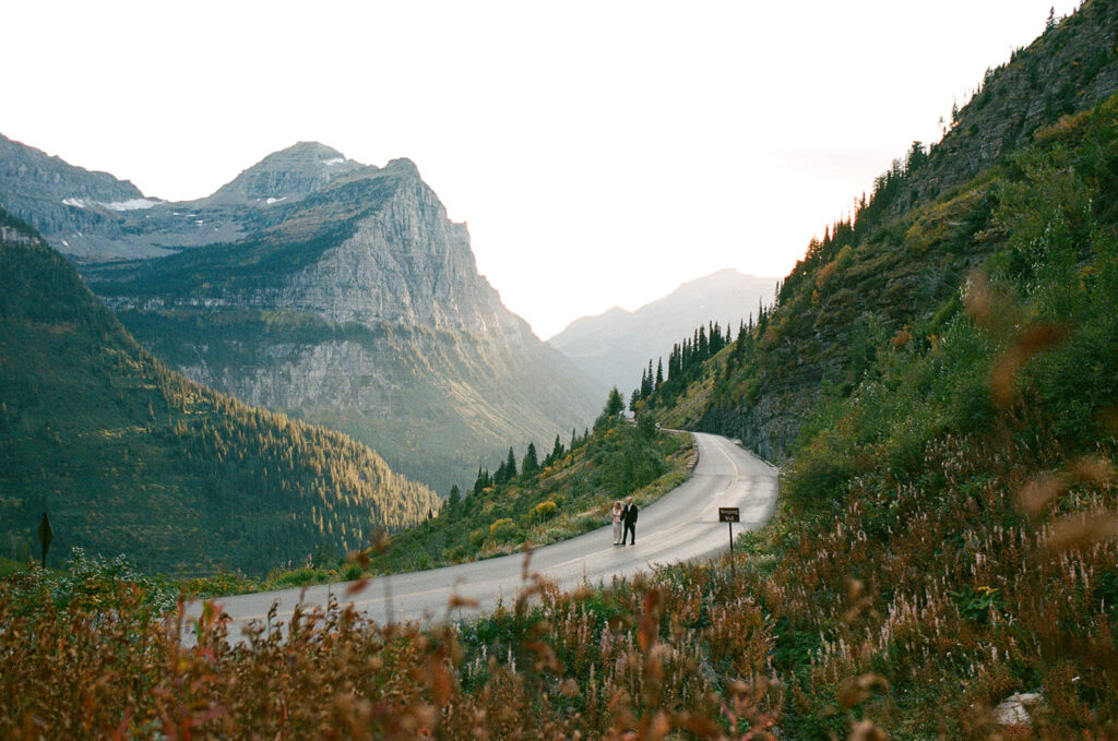 Couple runs on road in Glacier National Park