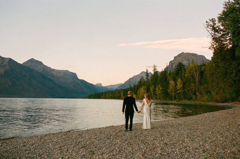 Couple stands by lake in Glacier National Park