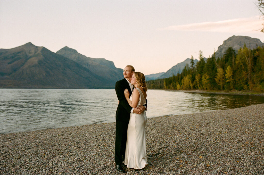 Couple stands by lake in Glacier National Park