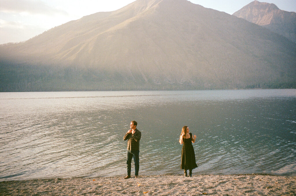 Couple stands next to Lake McDonald