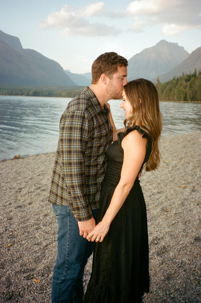 Couple stands next to Lake McDonald