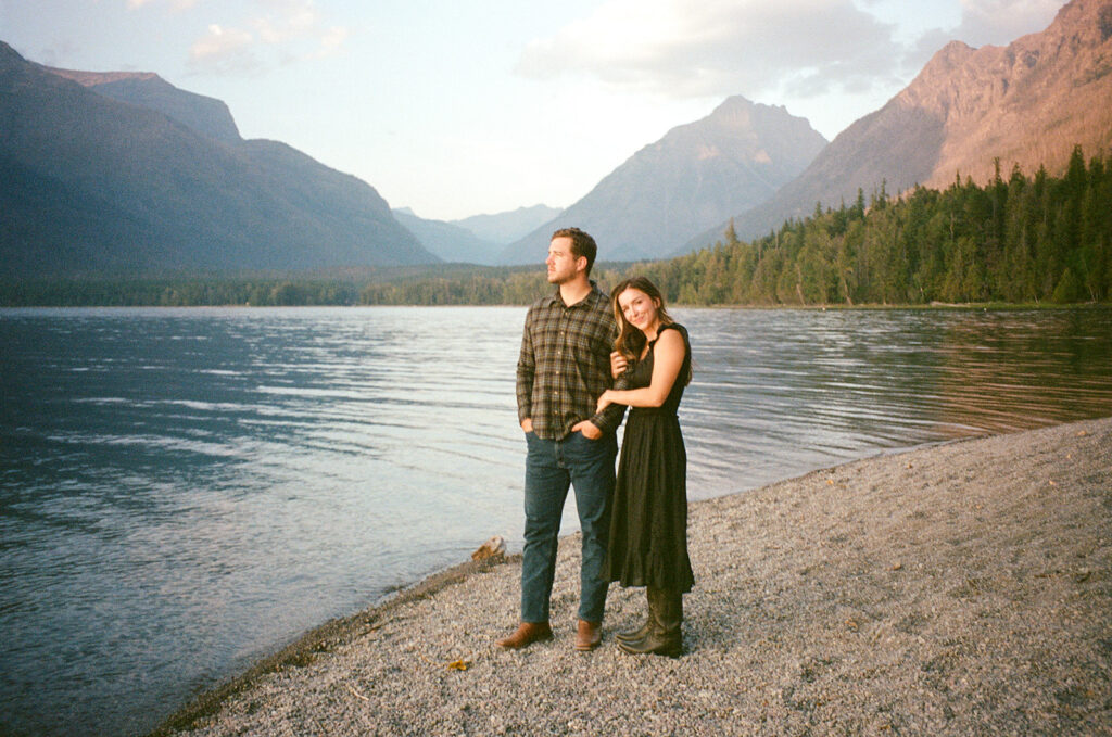 Couple stands next to Lake McDonald