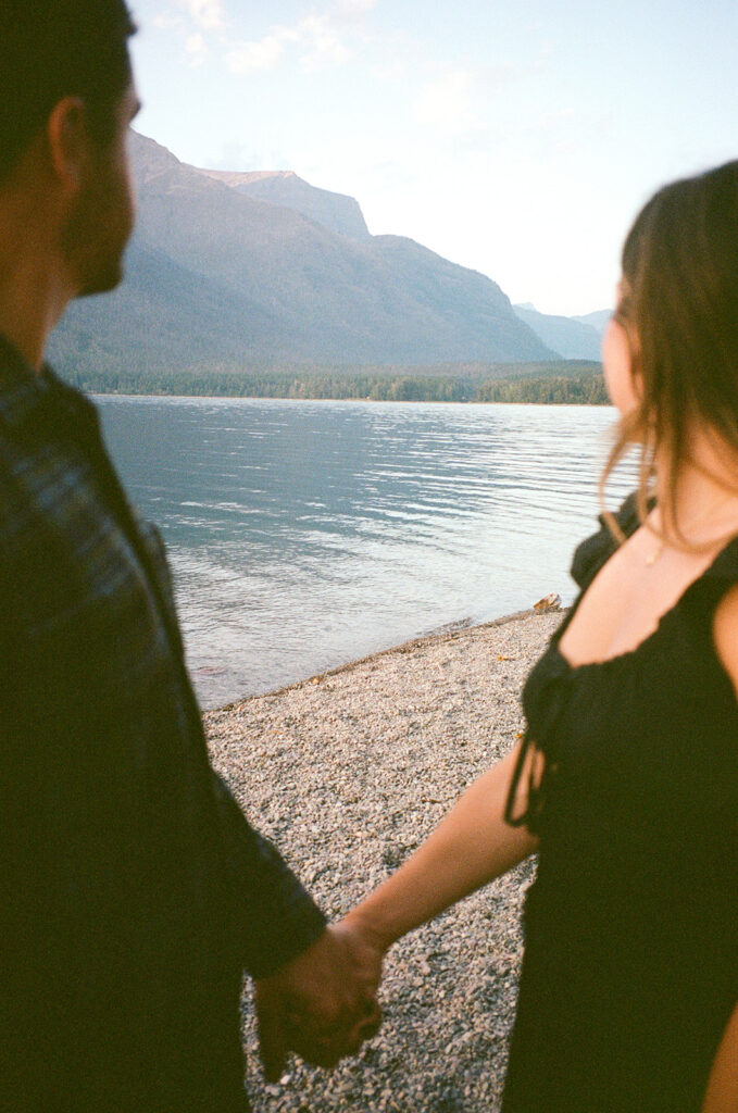 Couple stands next to Lake McDonald