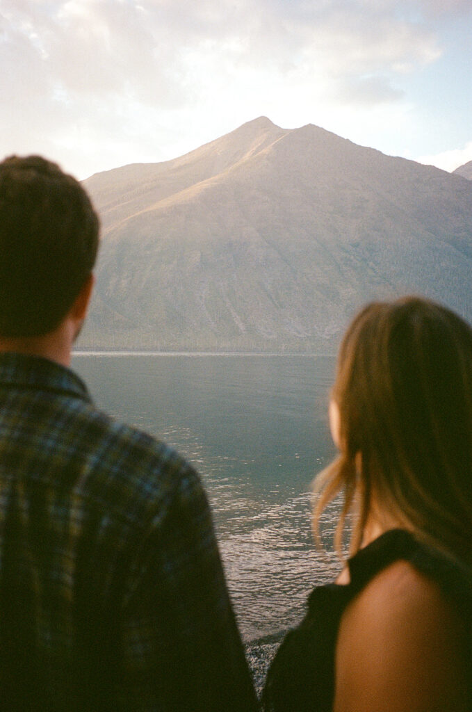 Couple stands next to Lake McDonald