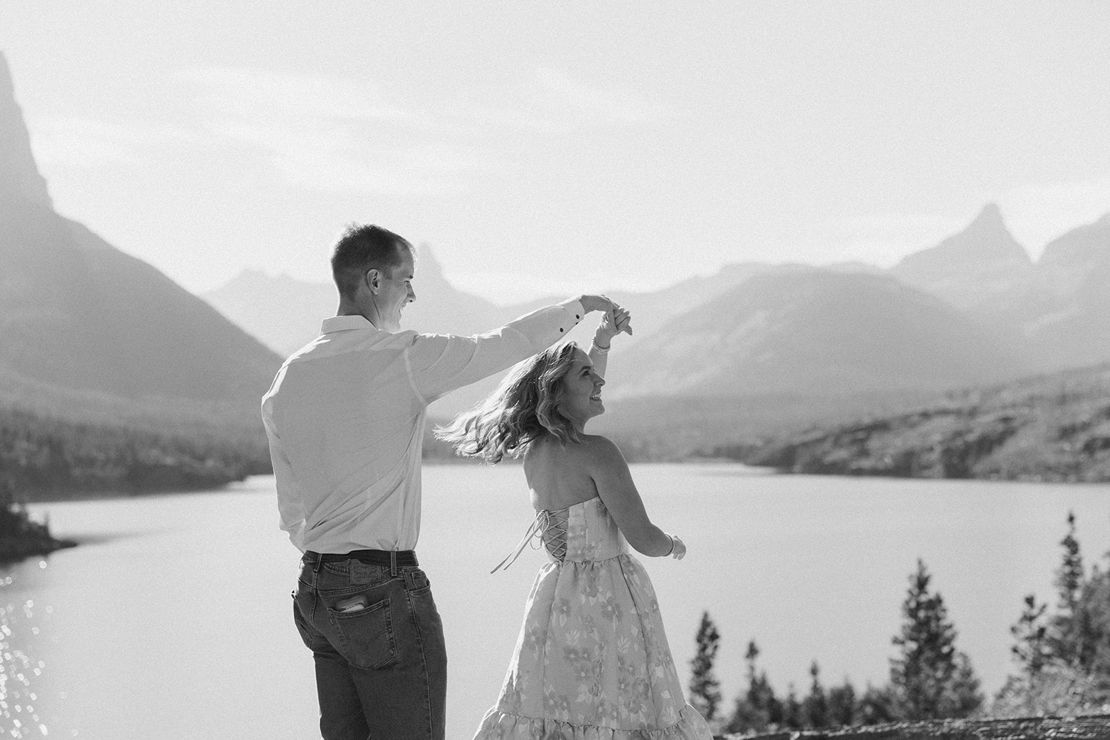 Black and white photo of couple twirling 