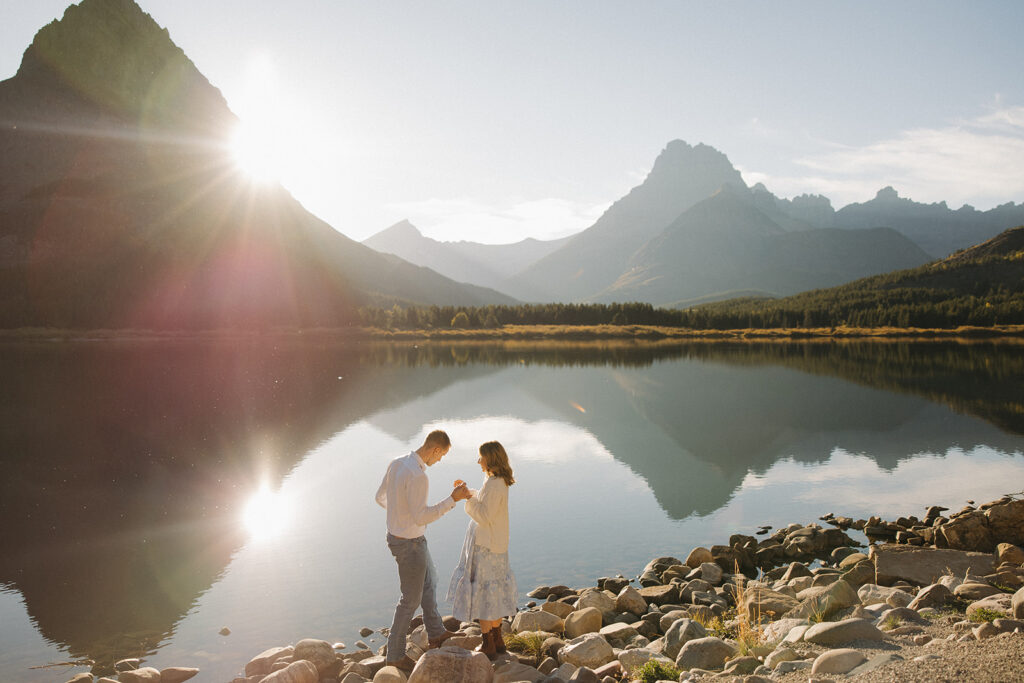 Couple standing on the rocks at Swiftcurrent Lake in Glacier National Park