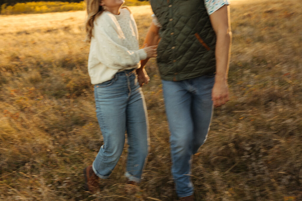 Slightly blurry photo of couple running in a field in Glacier National Park