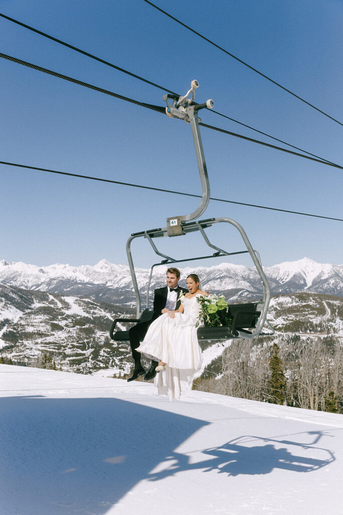 Luxury Yellowstone Club Wedding couple riding ski lift in wedding attire